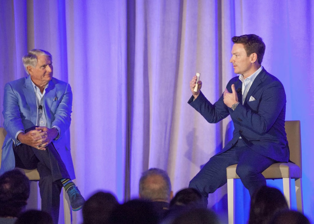 Dr. Brumm holding a porcelain restoration during a live case demo on stage