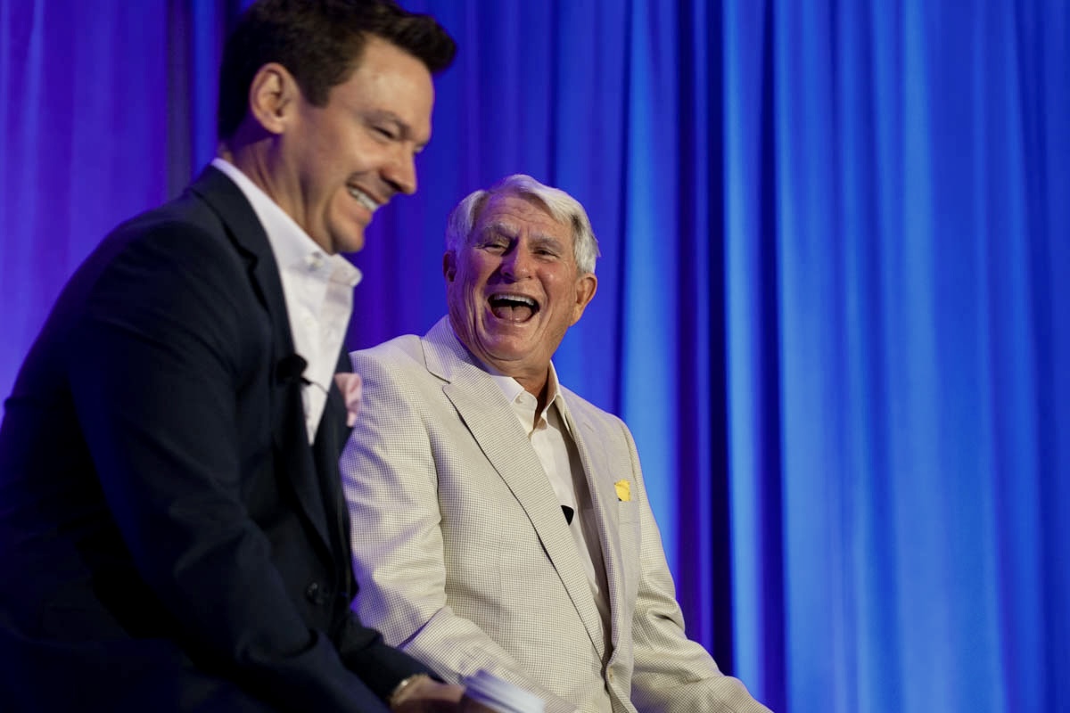 Dr. Strupp and Dr. Brumm laughing on stage during a Simplifying Complex seminar